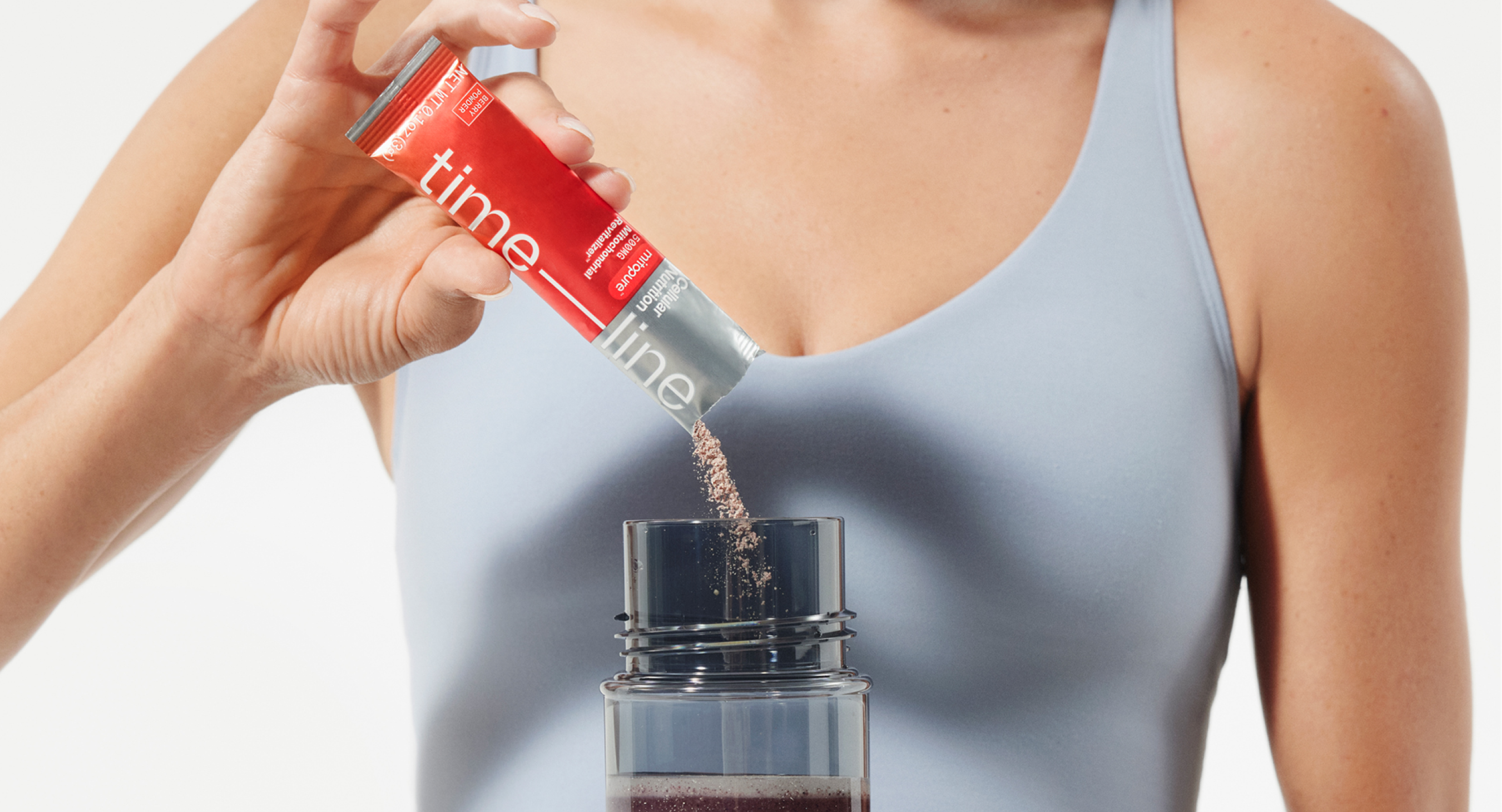 Person pouring Mitopure Berry Powder in a bottle