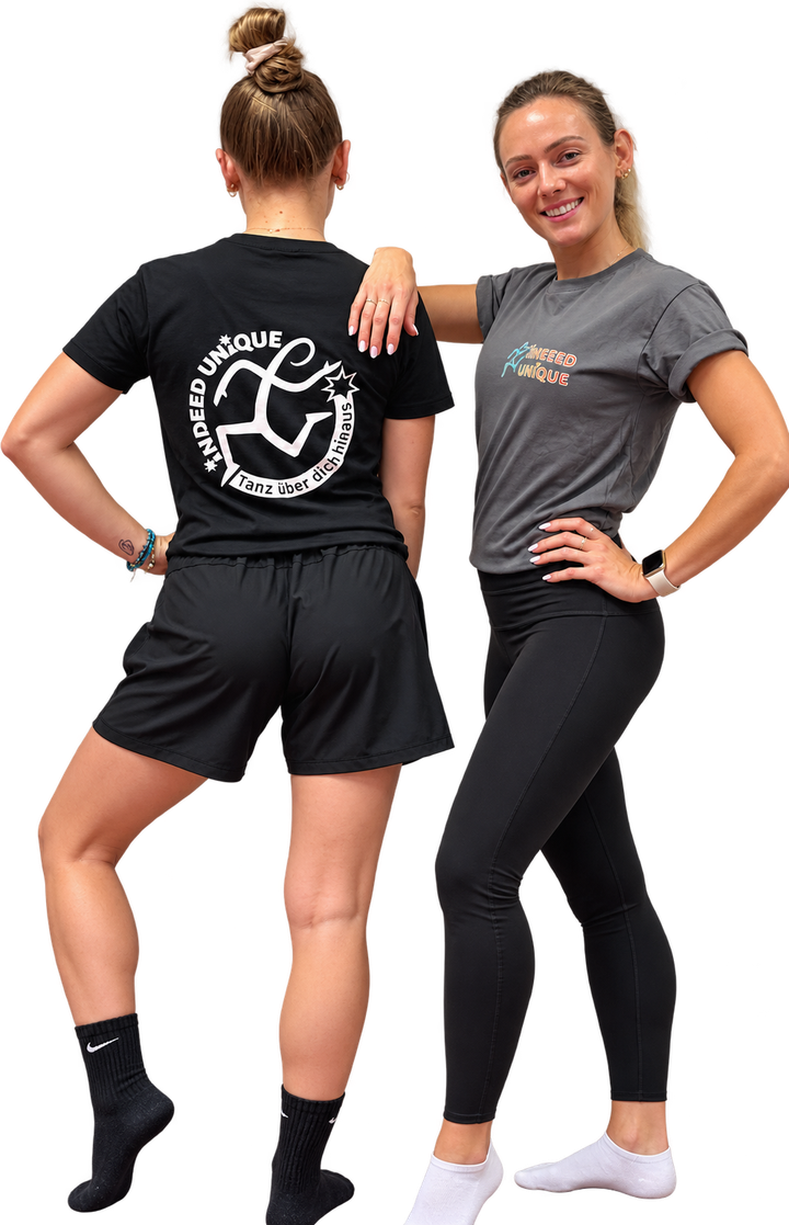 Zwei Trainerinnen: schwarzes Shirt mit weißem Logo am Rücken, graues Shirt mit farbigem Schriftzug auf der Brust