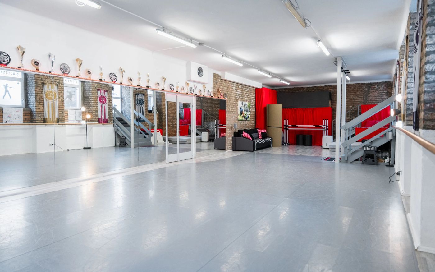 Studio „Unique“: Blick durch den Saal zur Bühnenecke mit rotem Vorhang
