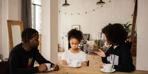 Two parents speaking to a child about emotional literacy