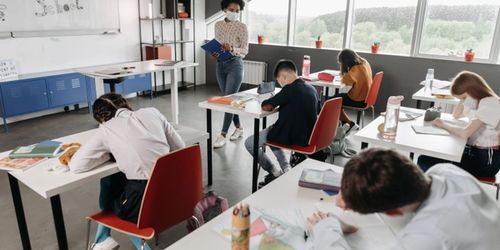 Students writing at their desks in a classoom