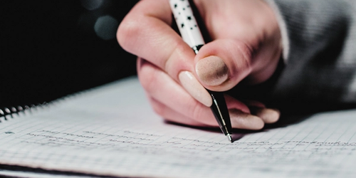 A student writing, breaking down complex writing tasks