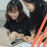 Two students working on a laptop together