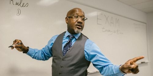 A teacher writing on a whiteboard