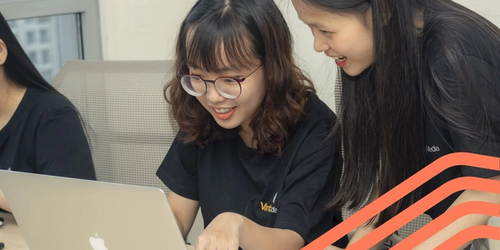 Two students working on a laptop together