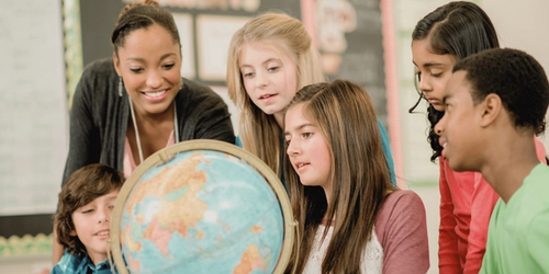 Learners and a teacher looking at a globe