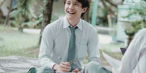A boy in a school uniform doing work.