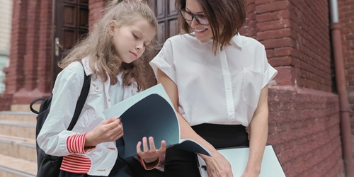 A student reading with a teacher.