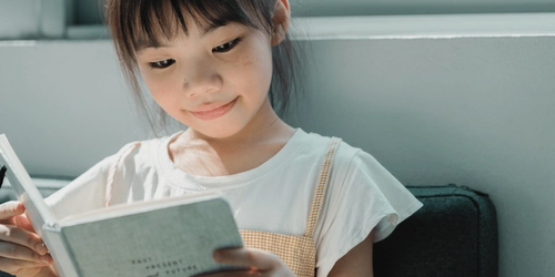 A child reading a book at home.