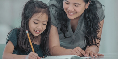 A parent helping their child put literacy knowledge into action