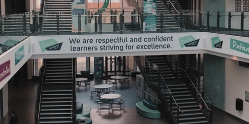 A image of Oasis Academy Oldham with their slogan, "We are respectful and confident learners striving for excellence."