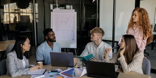 Five people collaborating on strategy around a table