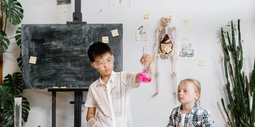 Two children doing science experiments in a science classroom