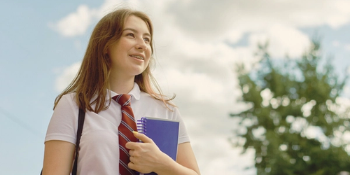 A student holding a notepad.