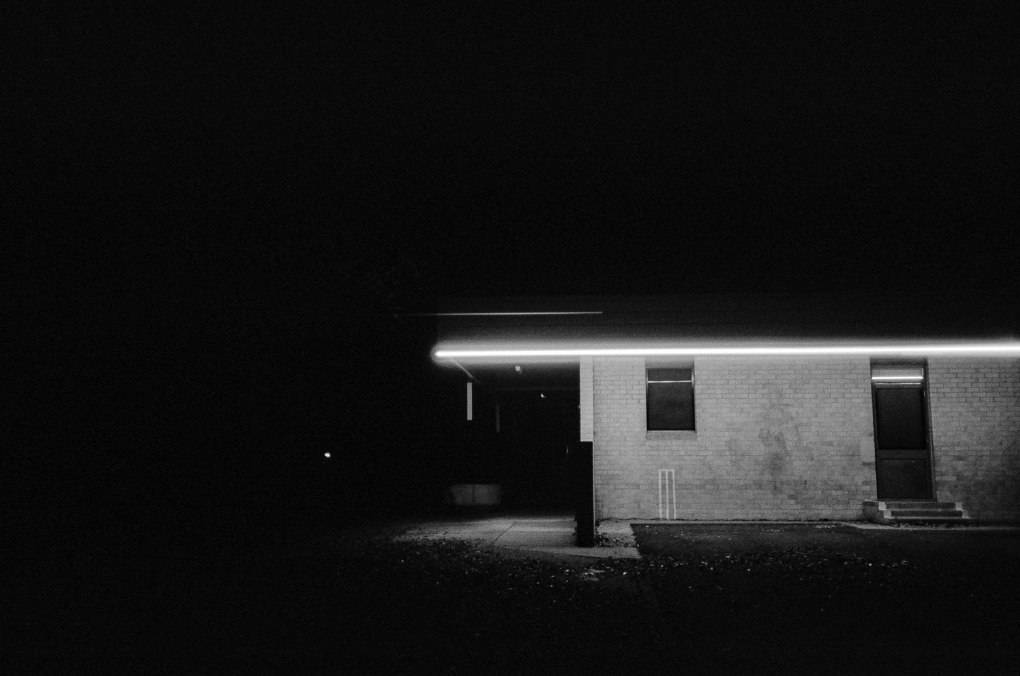 Black and white: a low building lit at night.