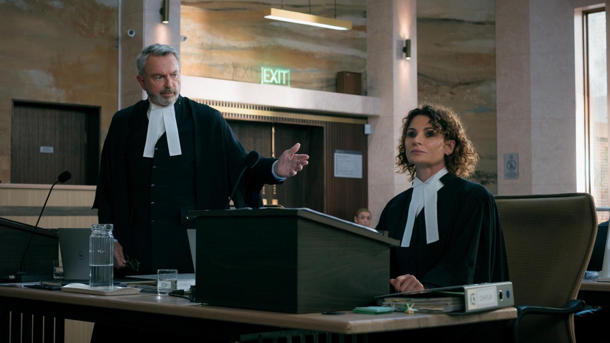 Sam Neill, in barrister's wig and gown, addresses a courtroom.