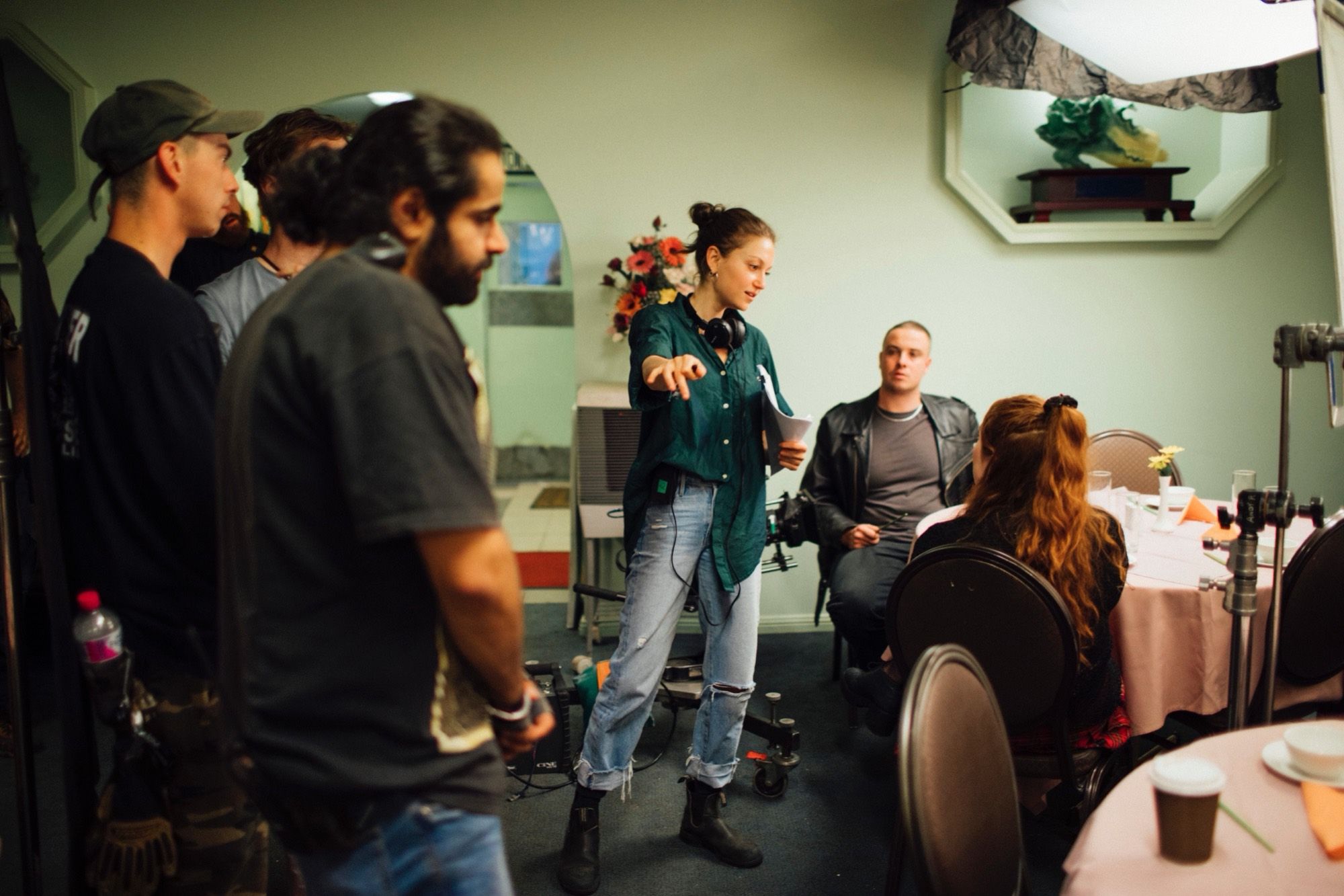 On set in the restaurant: a woman directs, crew gathered around her.