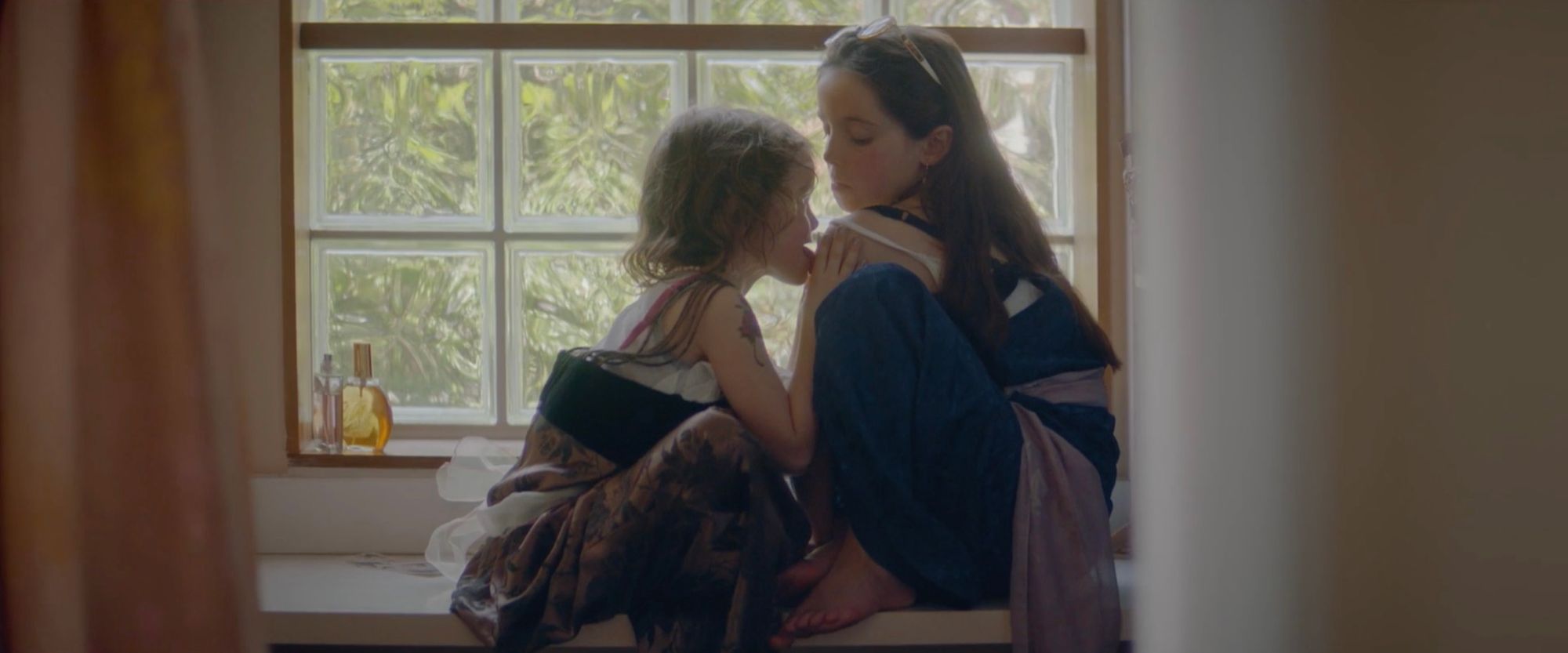 Two sisters by a window.