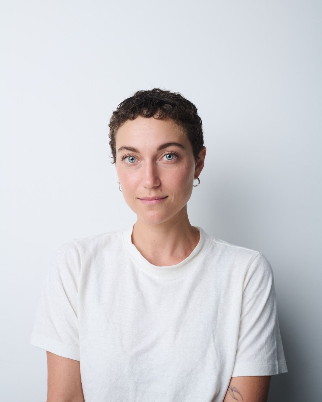 Portrait of Madeleine Gottlieb in a white t-shirt against a pale background.