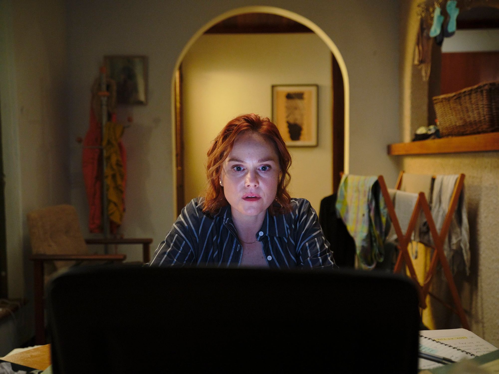 Eryn Jean Norvill at a desk at night, lit by a screen.