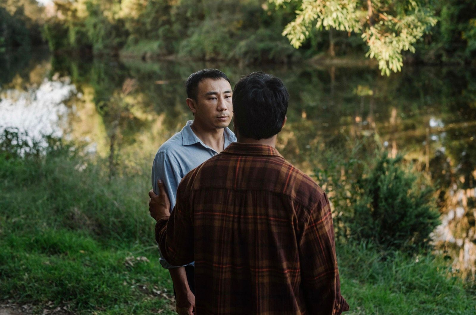 Two men outdoors by the water.