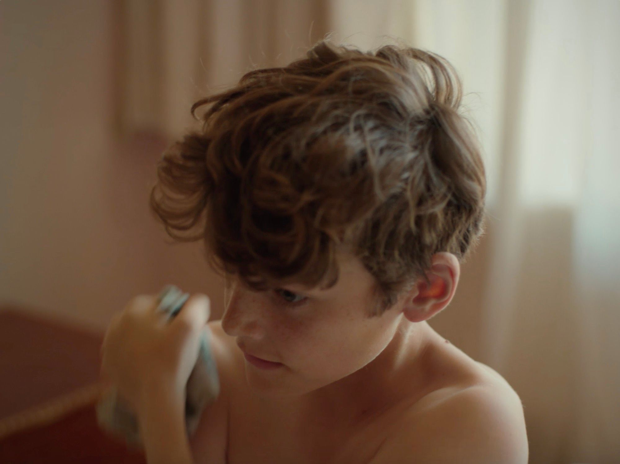 A boy with tousled hair, in close-up.