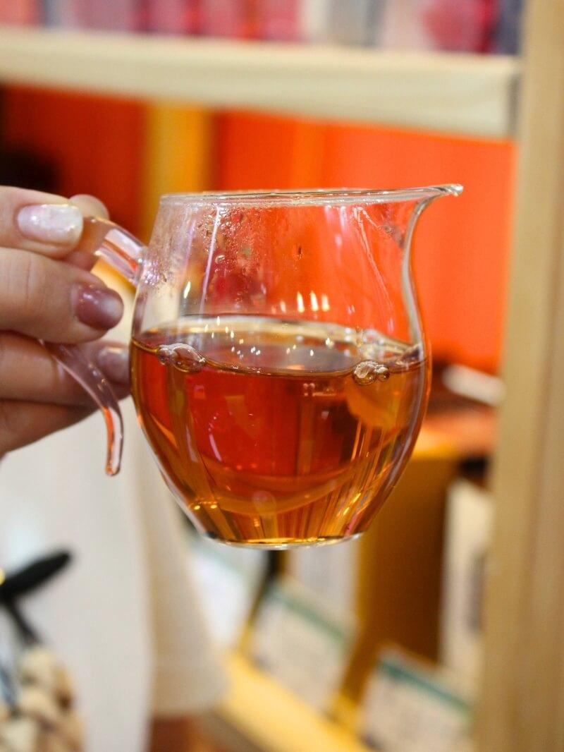 A small glass pitcher of deep amber-red tea.