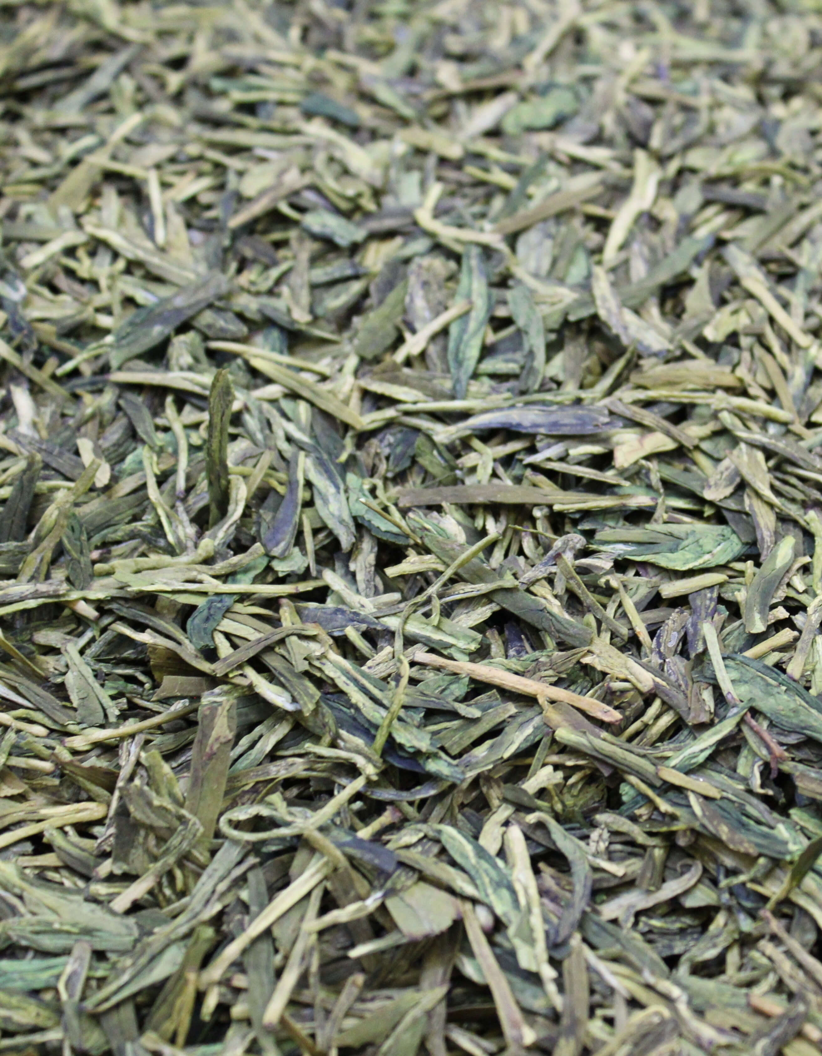 Flat blade-shaped green tea leaves.
