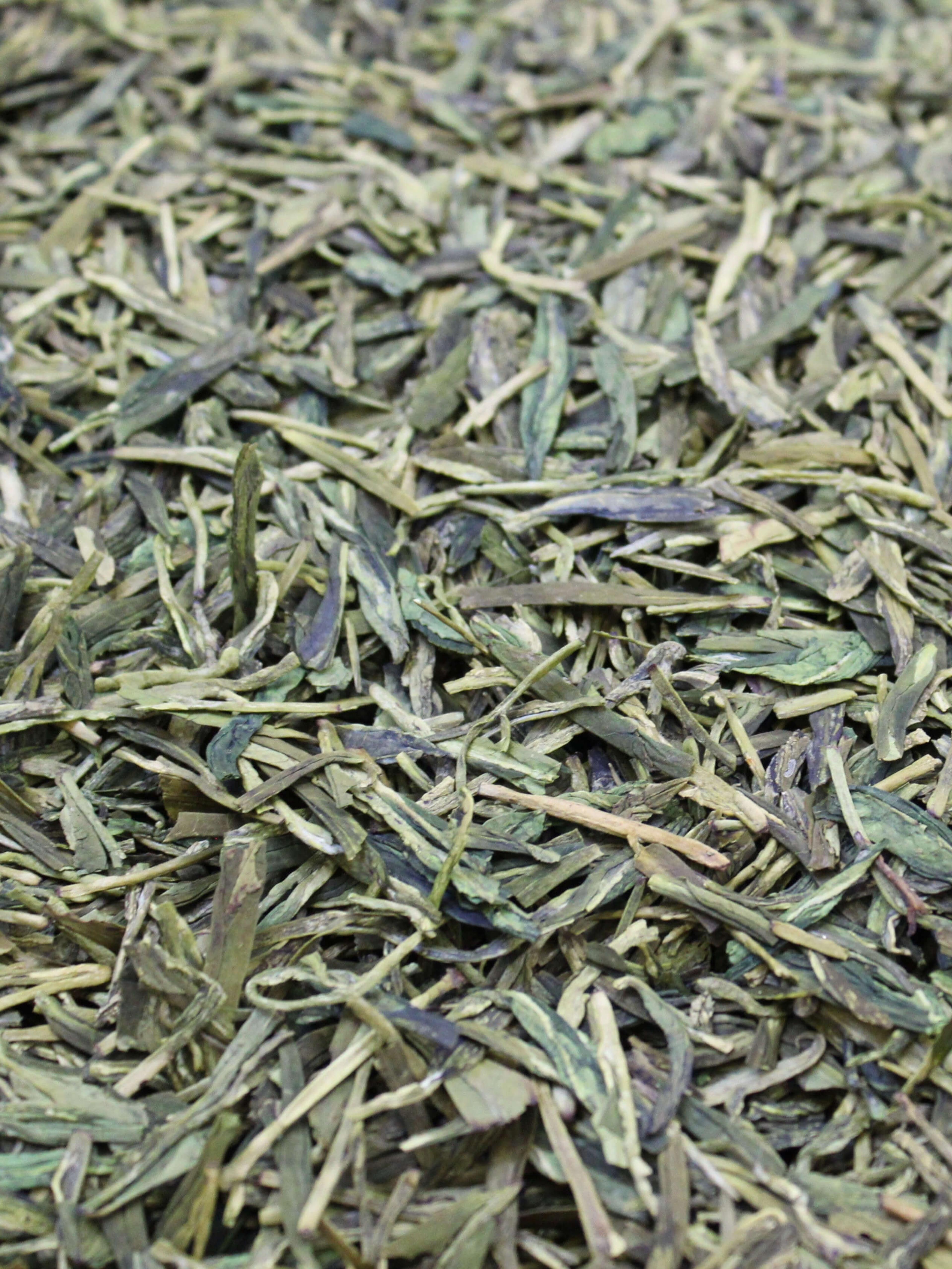 Flat blade-shaped green tea leaves.