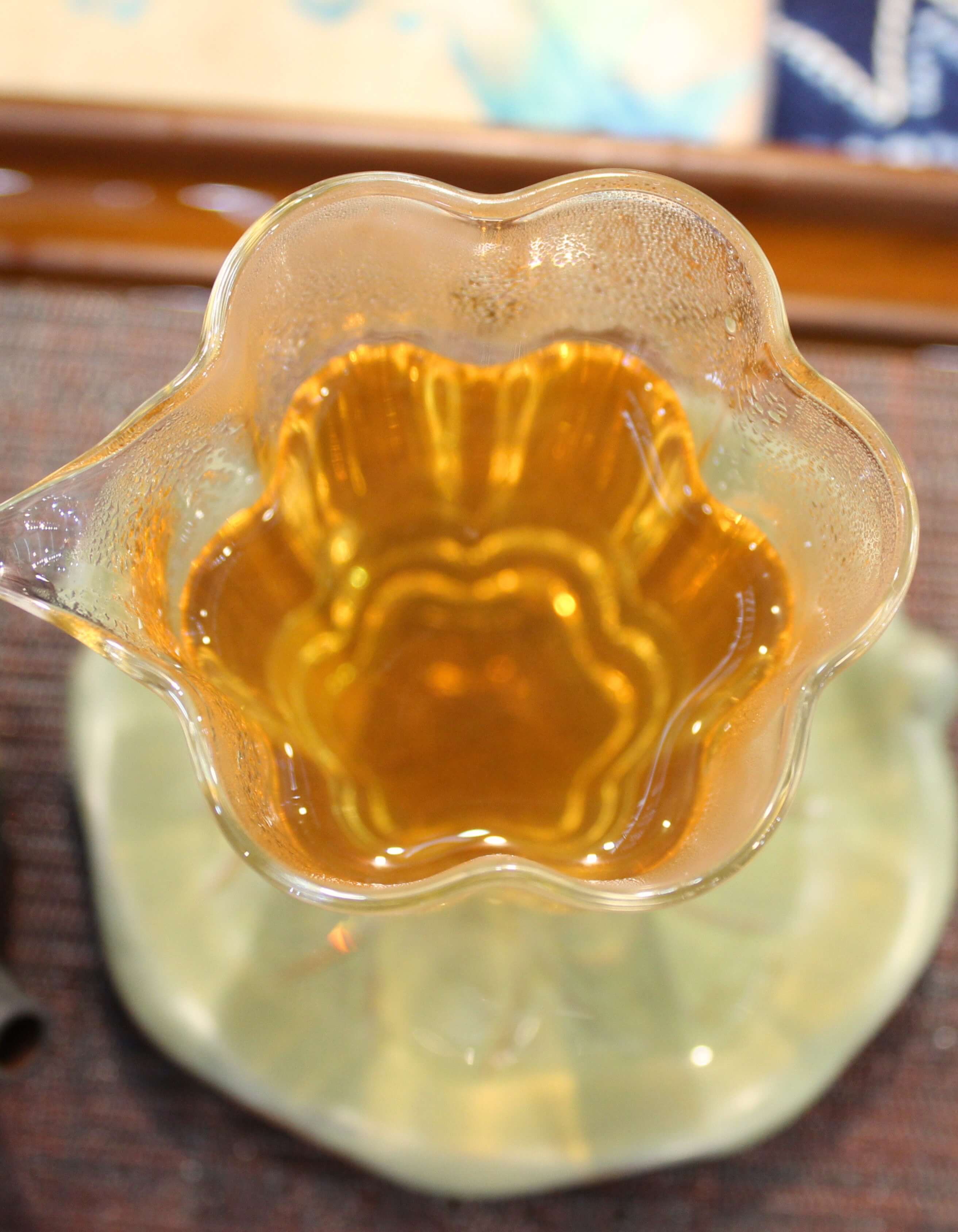 Golden tea in a fluted glass pitcher, from above.