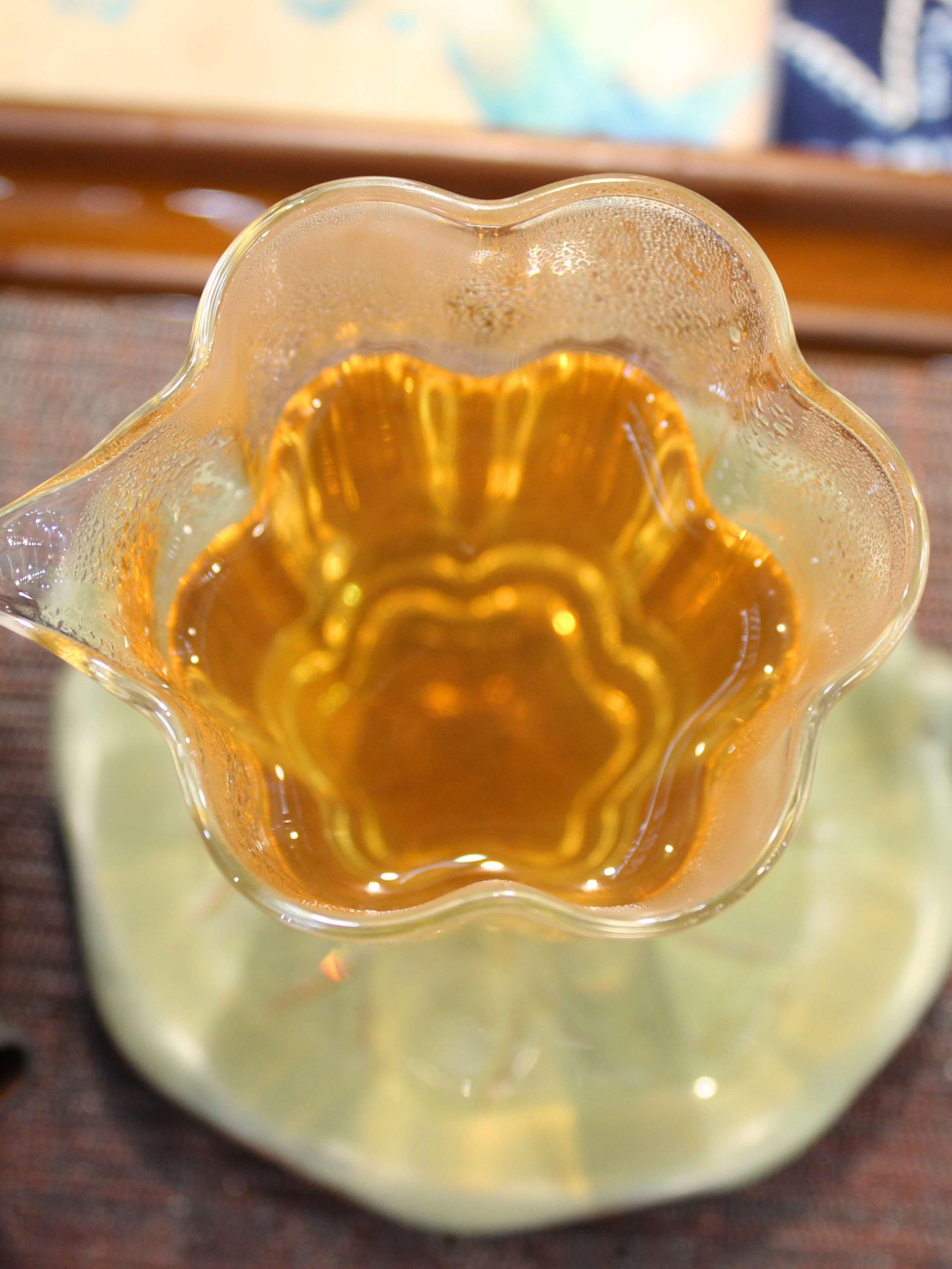 Golden tea in a fluted glass pitcher, from above.