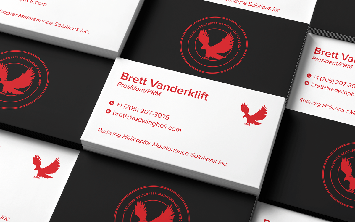 Stacked business cards for a helicopter maintenance company featuring a red eagle logo on black and white card designs.