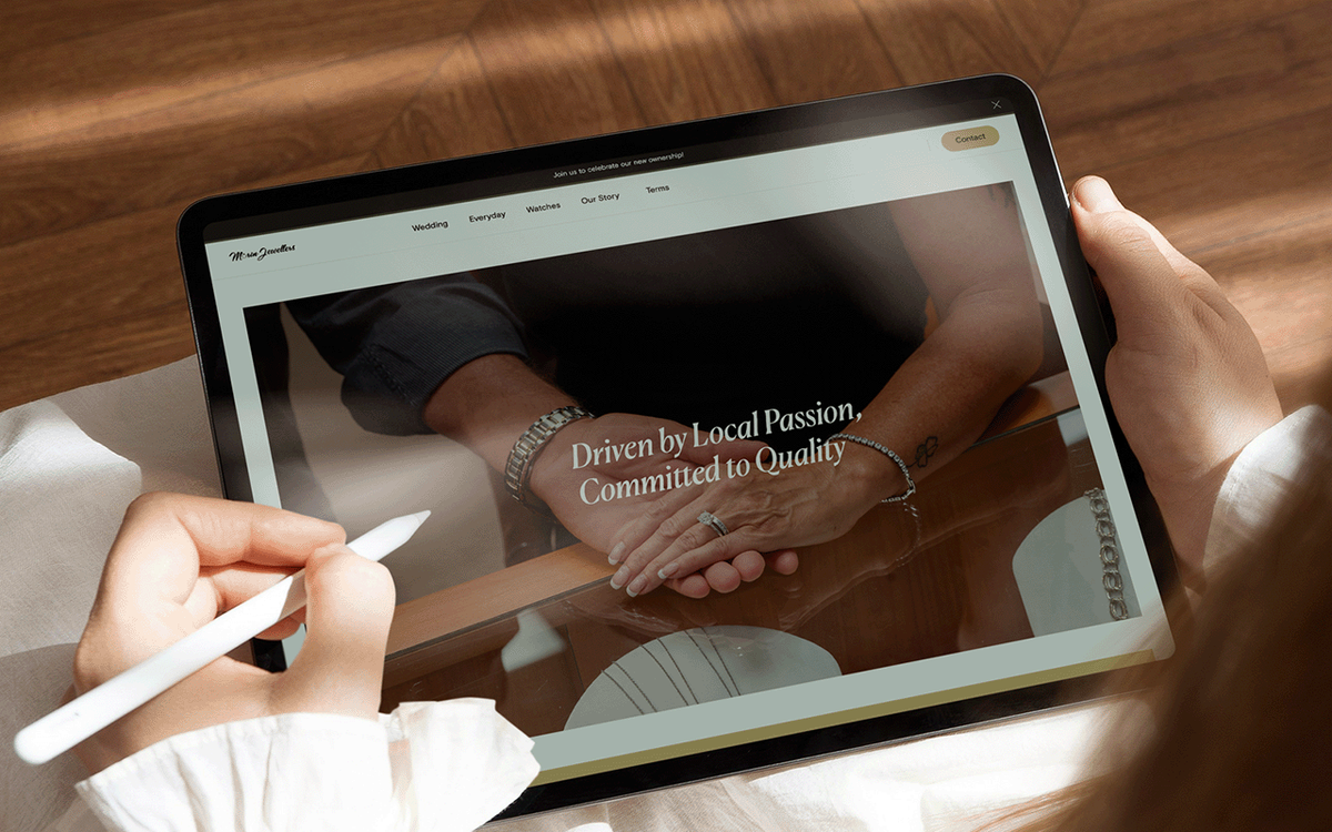 Tablet held by a person, displaying a jewellery store homepage with a hands-clasped photo wearing bracelets and rings, and the headline 'Driven by Local Passion, Committed to Quality.