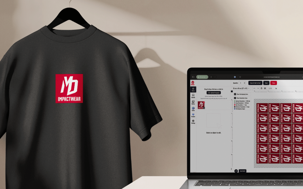 A black t-shirt on a hanger with an Impactwear chest logo, next to a laptop showing print layout software with a repeated logo sheet.