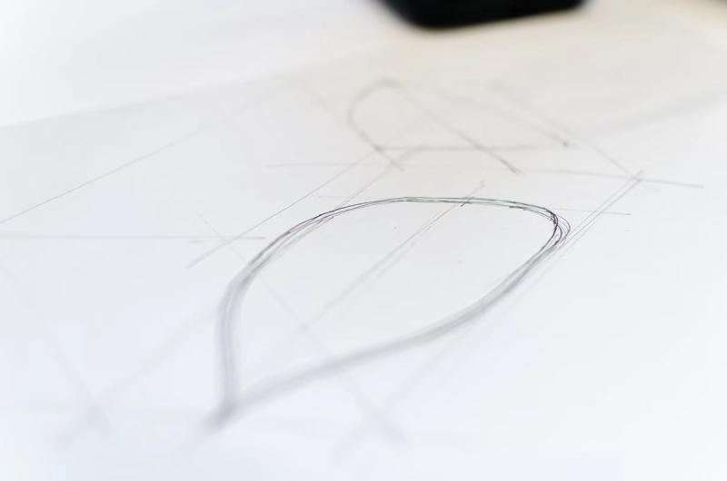 a loose profile of the bottom of a clothes iron sketched on A4 paper