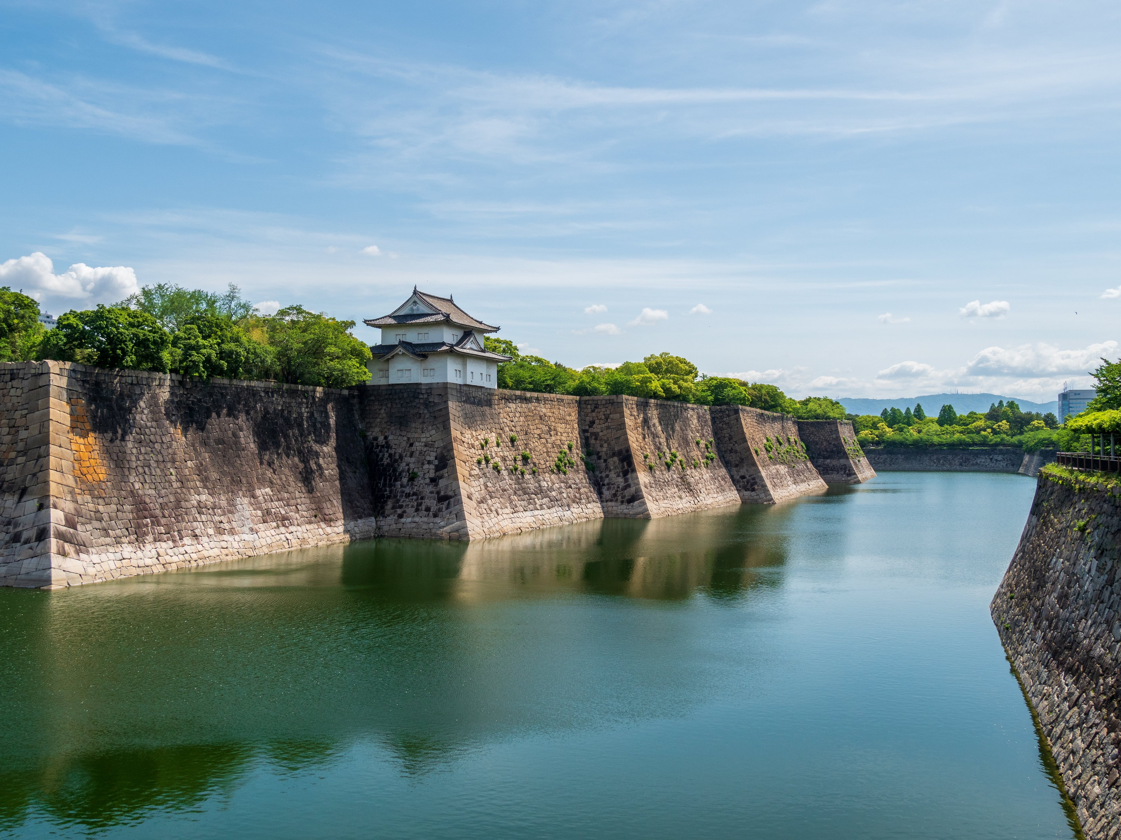 a large stone wall surrounds a large body of water .