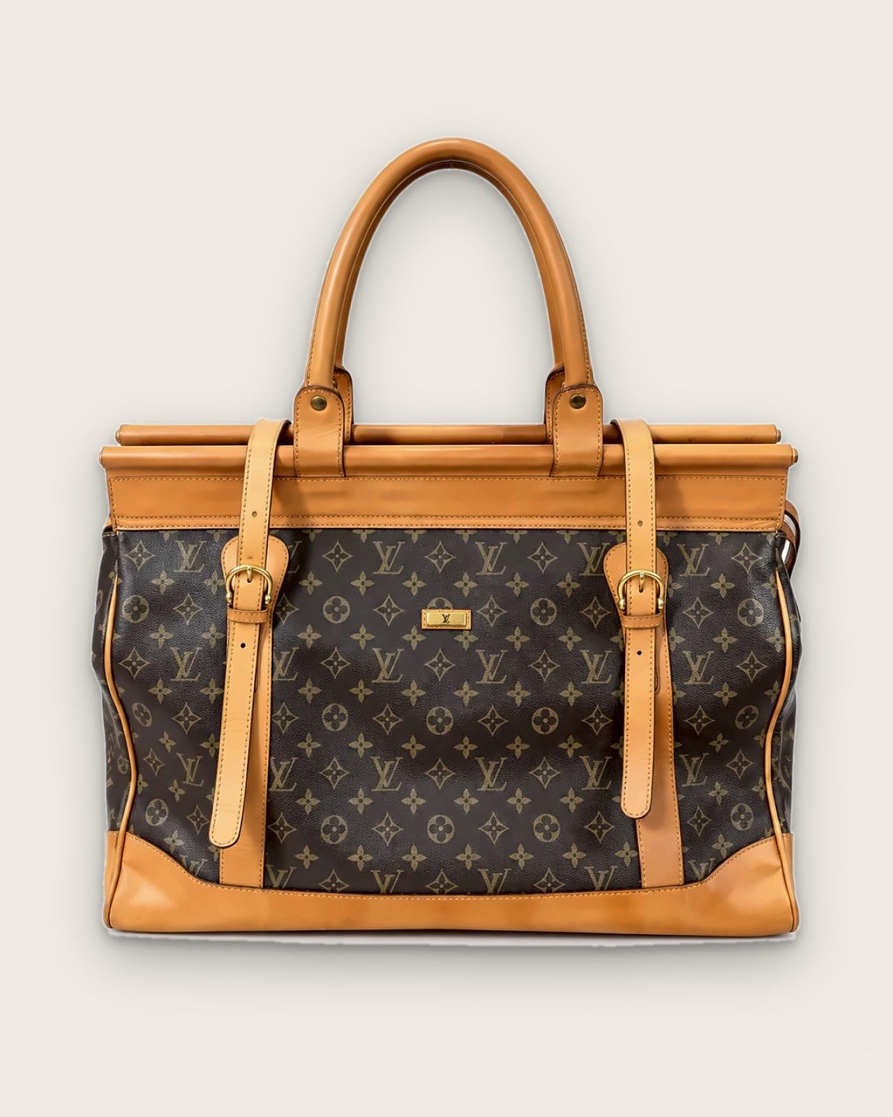 Monogram canvas travel bag with light leather handles and straps