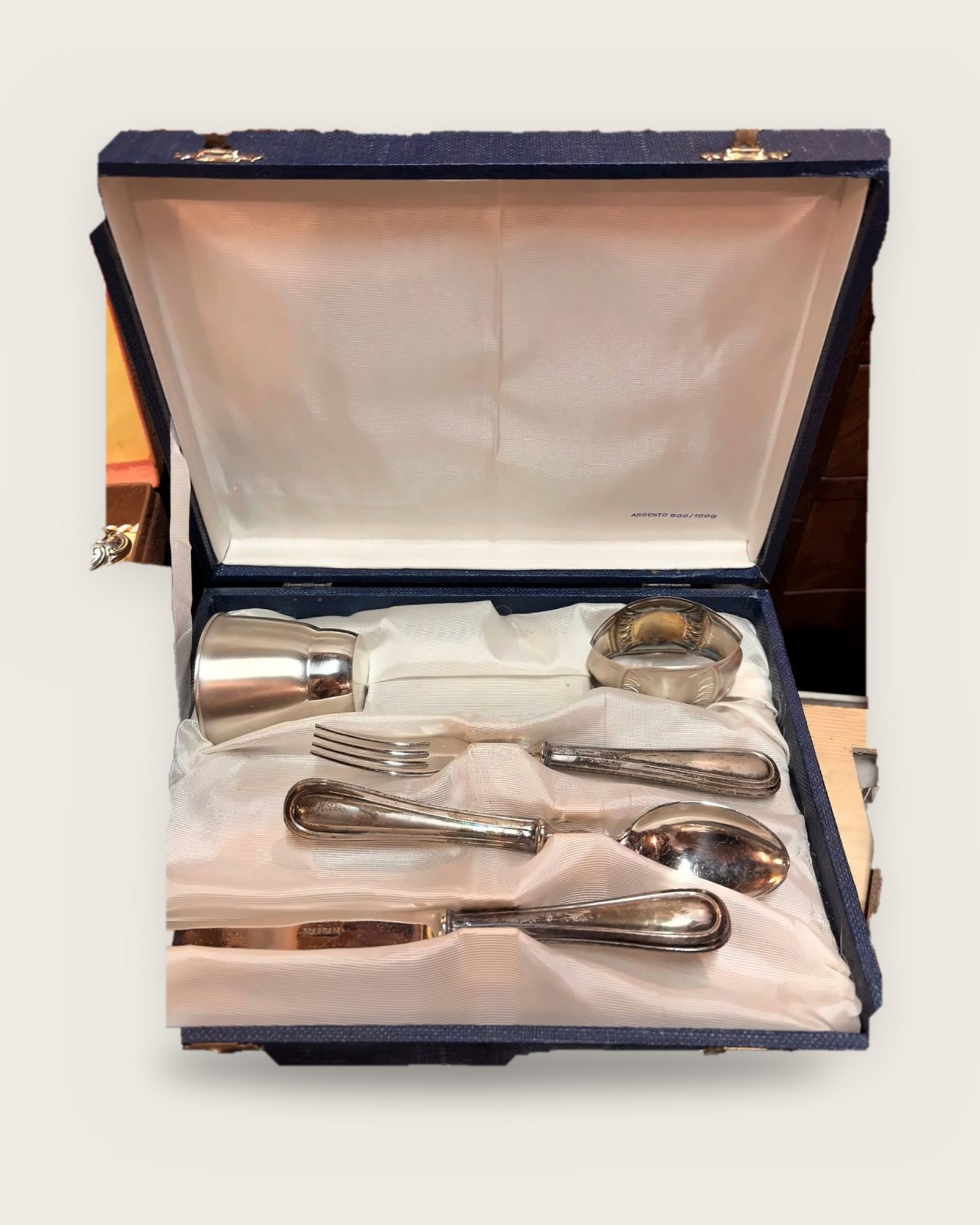 Cup, napkin ring and cutlery in a blue case lined with white satin