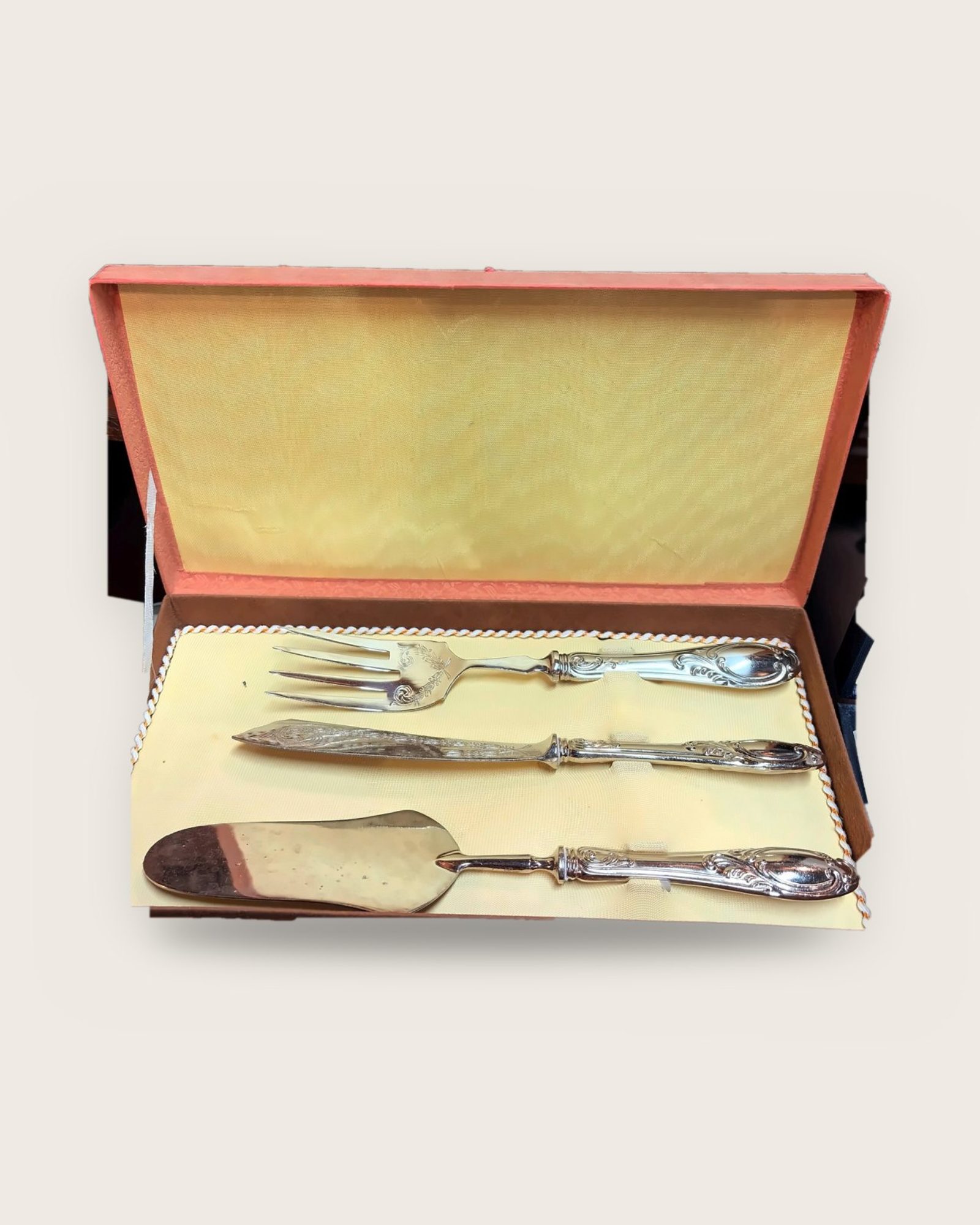 Serving fork, knife and server with scrolled handles in an orange case lined in yellow