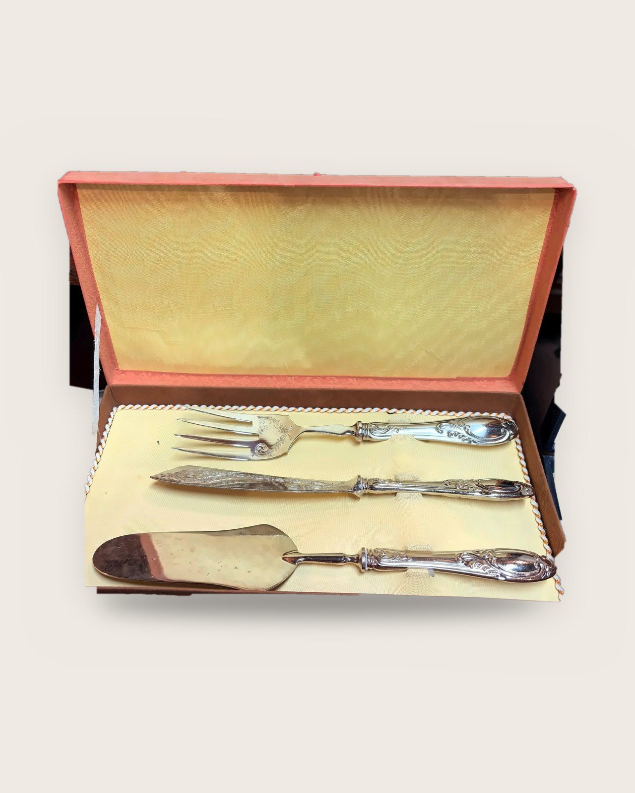 Serving fork, knife and server with scrolled handles in an orange case lined in yellow