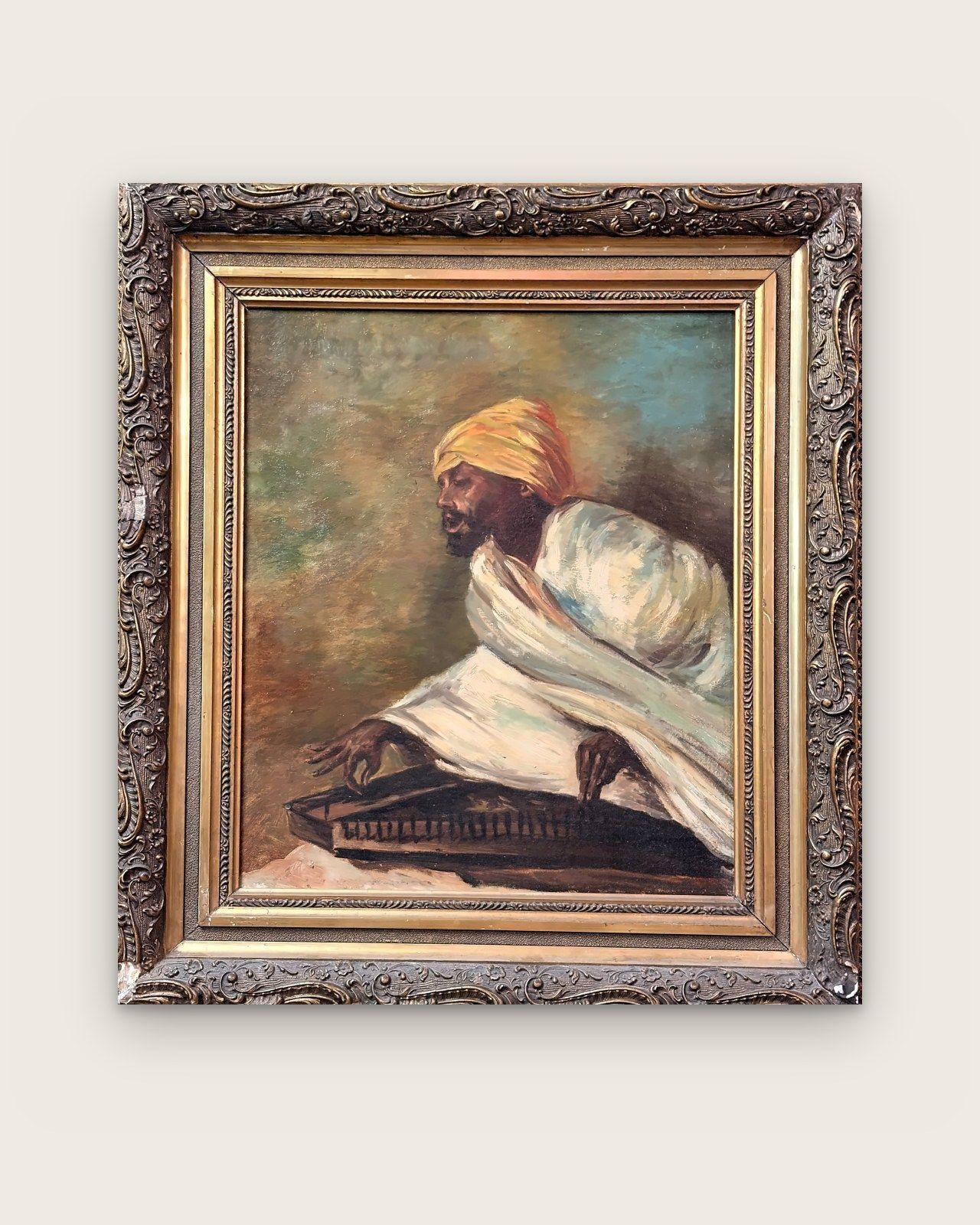 Painting: musician in a yellow turban playing a string instrument, in an ornate gilded frame