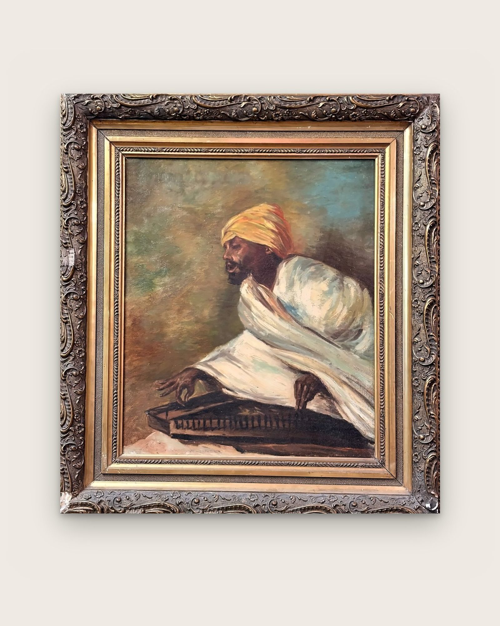Dipinto: musicista con turbante giallo che suona uno strumento a corde, in cornice dorata decorata