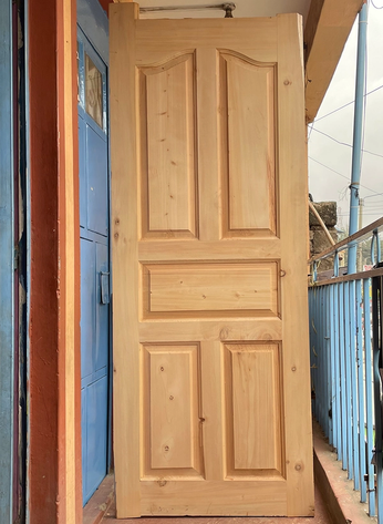 Cypress 5 panel solid wooden door with natural timber finish installed in a residential property in Kenya