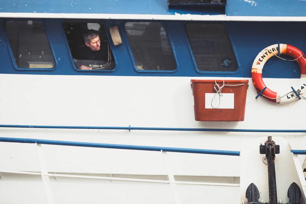 The skipper of the Venture maneuvers alongside the pier, Scalloway