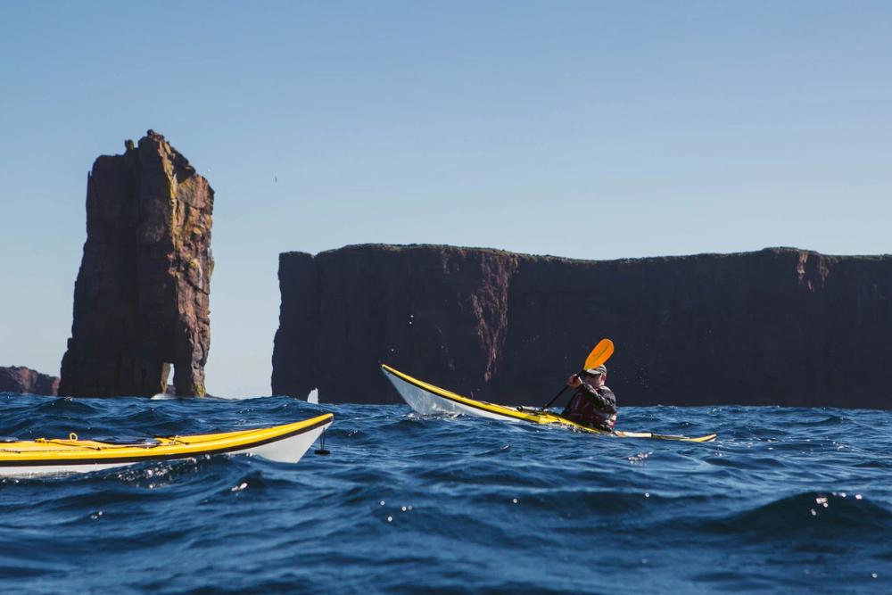 Kayaker in front of sea stacks