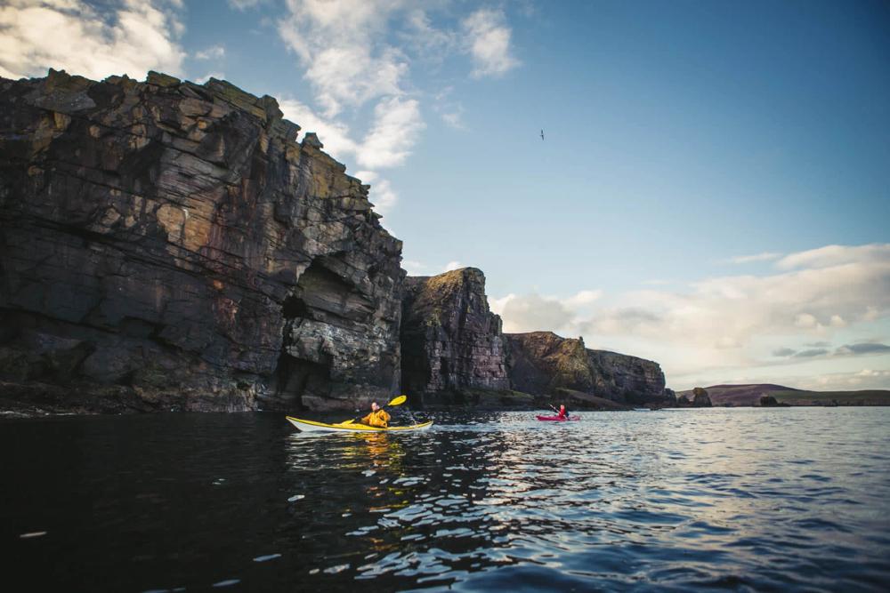 Kayakers below cliffs