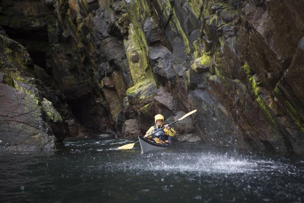 Kayaker under a waterfall