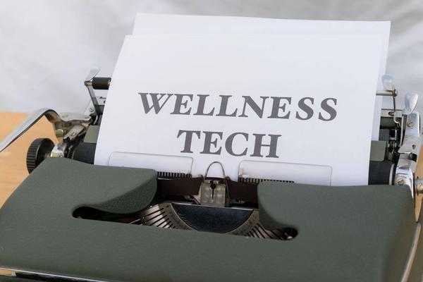 Vintage typewriter with a sheet of paper reading "Wellness Tech"