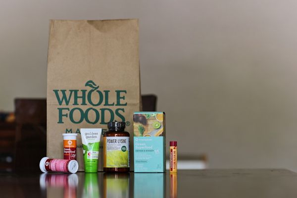Whole Foods paper bag with supplements and wellness products arranged on a wooden table
