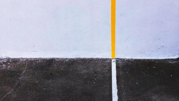 yellow line on wall meeting white line on black pavement
